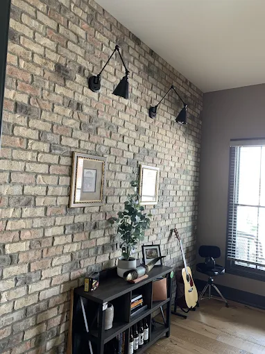 Designer wall sconces on an exposed brick accent wall